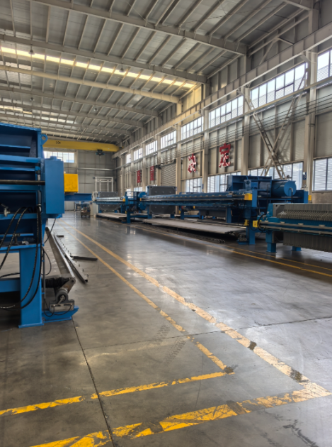 鄭州樸華科技現(xiàn)代化的環(huán)保設(shè)備生產(chǎn)基地內(nèi)部，展示加工設(shè)備和組裝中的大型壓濾機